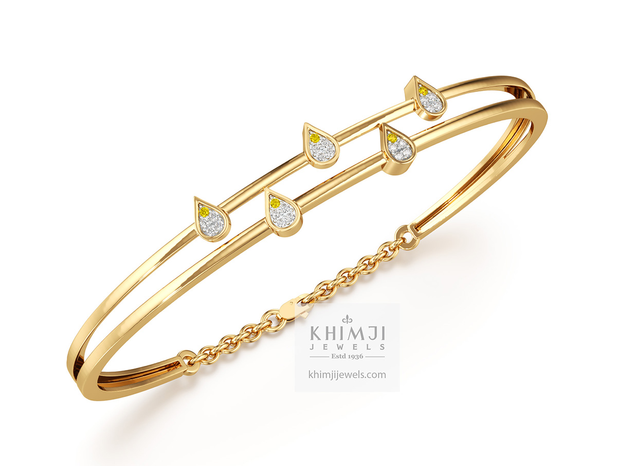 The gold bangle is dotted with diamond leaves. By Khimji Jewels